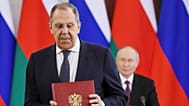 FILE: Russian Foreign Minister Sergey Lavrov attends a signing ceremony with Russian President Vladimir Putin in the background, in Moscow, 22 April 2025